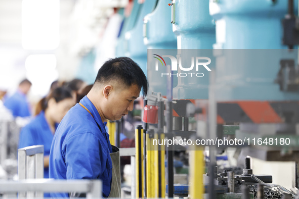 Workers work at the production workshop of Jiangsu Xinhua Auto Parts Co LTD in Sihong Economic Development Zone in Suqian, Jiangsu province,...