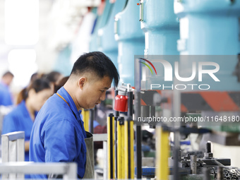 Workers work at the production workshop of Jiangsu Xinhua Auto Parts Co LTD in Sihong Economic Development Zone in Suqian, Jiangsu province,...