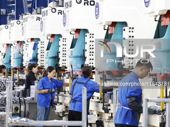 Workers work at the production workshop of Jiangsu Xinhua Auto Parts Co LTD in Sihong Economic Development Zone in Suqian, Jiangsu province,...