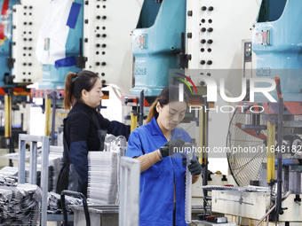 Workers work at the production workshop of Jiangsu Xinhua Auto Parts Co LTD in Sihong Economic Development Zone in Suqian, Jiangsu province,...