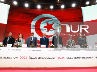 The head of the Tunisian election commission, Farouk Bouasker, along with other members of the Tunisian election commission, sings Tunisia's...