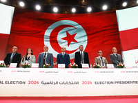 The head of the Tunisian election commission, Farouk Bouasker, along with other members of the Tunisian election commission, sings Tunisia's...