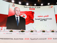 A giant screen displays a national flag of Tunisia with a portrait of Tunisia's president, Kais Saied, and the text in Arabic, ''Kais Saied...