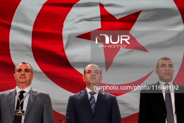 The head of the Tunisian election commission, Farouk Bouasker, along with other members of the Tunisian election commission, sings Tunisia's...