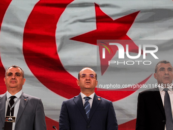 The head of the Tunisian election commission, Farouk Bouasker, along with other members of the Tunisian election commission, sings Tunisia's...