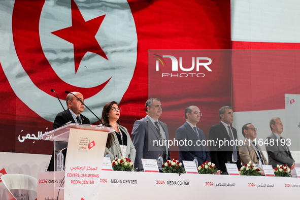 The head of the Tunisian election commission, Farouk Bouasker, along with other members of the Tunisian election commission, sings Tunisia's...