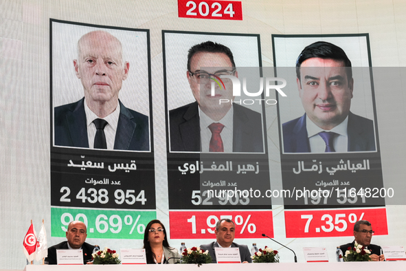 Members of the Tunisian election commission attend a press conference to announce the preliminary results of the presidential election, whil...