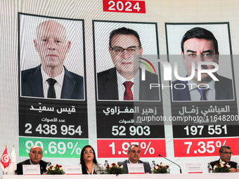 Members of the Tunisian election commission attend a press conference to announce the preliminary results of the presidential election, whil...