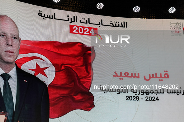 A giant screen displays a national flag of Tunisia with a portrait of Tunisia's president, Kais Saied, and the text in Arabic, ''Kais Saied...