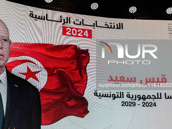 A giant screen displays a national flag of Tunisia with a portrait of Tunisia's president, Kais Saied, and the text in Arabic, ''Kais Saied...