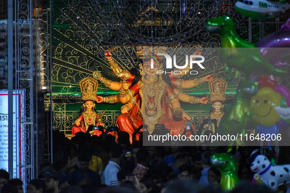 Devotees arrive to see an idol of Goddess Durga at a pandal during the Durga Puja celebration in Kolkata, India, on October 7, 2024. 