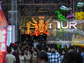 Devotees arrive to see an idol of Goddess Durga at a pandal during the Durga Puja celebration in Kolkata, India, on October 7, 2024. (