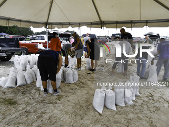 Residents of Orange County, Florida, collect sandbags for free to protect themselves from Hurricane Milton, which is expected this week. The...