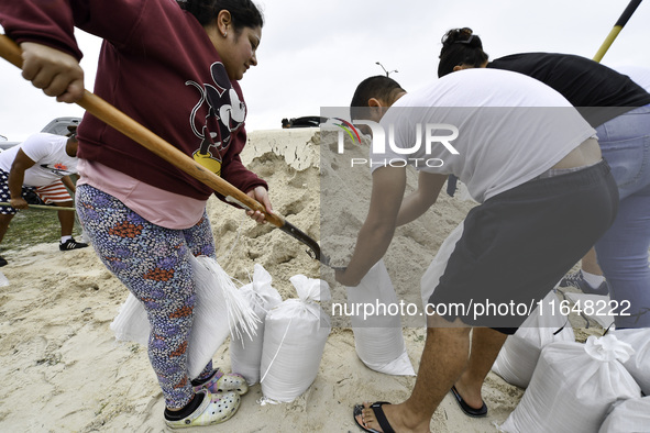 Residents of Orange County, Florida, collect sandbags for free to protect themselves from Hurricane Milton, which is expected this week. The...