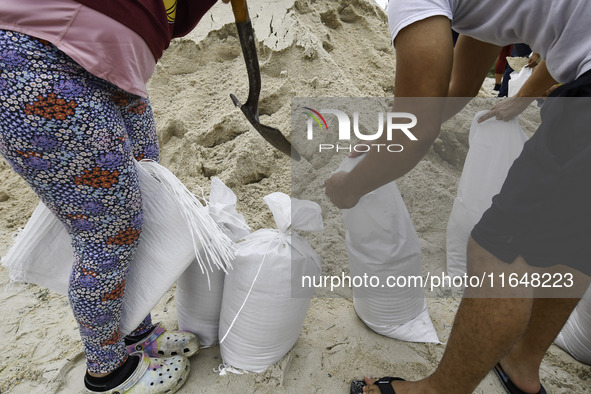 Residents of Orange County, Florida, collect sandbags for free to protect themselves from Hurricane Milton, which is expected this week. The...