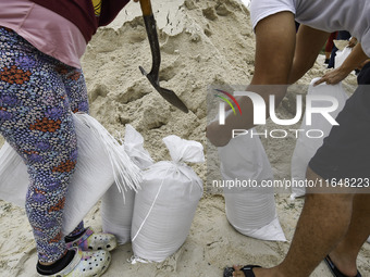 Residents of Orange County, Florida, collect sandbags for free to protect themselves from Hurricane Milton, which is expected this week. The...