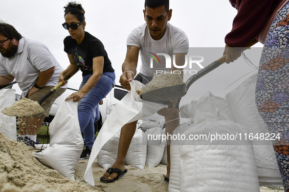 Residents of Orange County, Florida, collect sandbags for free to protect themselves from Hurricane Milton, which is expected this week. The...