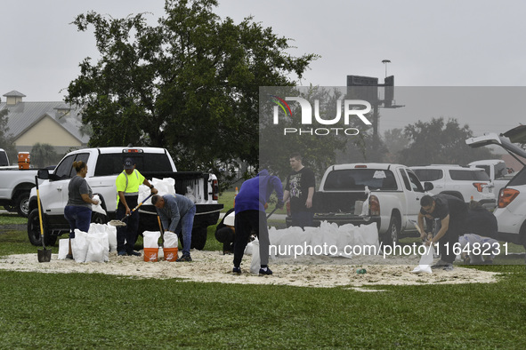 Residents of Orange County, Florida, collect sandbags for free to protect themselves from Hurricane Milton, which is expected this week. The...