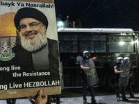 A man holds a sign with a picture of Hezbollah's deceased leader, Nasrallah, outside the Israeli Embassy in Athens, Greece, on October 7, 20...