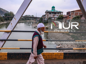 Kashmiri people walk early in the morning on the day of Assembly election results in Baramulla, Jammu and Kashmir, India, on October 8, 2024...