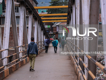 Kashmiri people walk early in the morning on the day of Assembly election results in Baramulla, Jammu and Kashmir, India, on October 8, 2024...