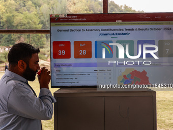 People watch the Assembly Election Results on a screen outside the counting hall in Baramulla, Jammu and Kashmir, India, on October 8, 2024...