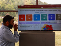 People watch the Assembly Election Results on a screen outside the counting hall in Baramulla, Jammu and Kashmir, India, on October 8, 2024...