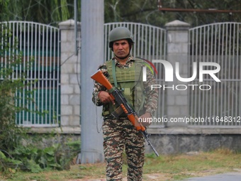 An Indian paramilitary soldier guards outside a vote counting center for the local assembly elections in Srinagar, Jammu and Kashmir, on Oct...