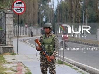 An Indian paramilitary soldier guards outside a vote counting center for the local assembly elections in Srinagar, Jammu and Kashmir, on Oct...