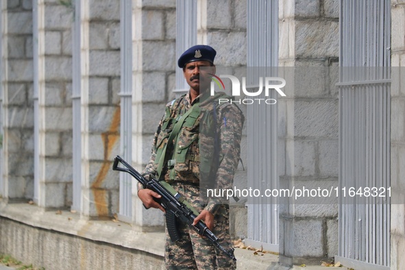 An Indian paramilitary soldier guards outside a vote counting center for the local assembly elections in Srinagar, Jammu and Kashmir, on Oct...