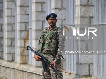 An Indian paramilitary soldier guards outside a vote counting center for the local assembly elections in Srinagar, Jammu and Kashmir, on Oct...