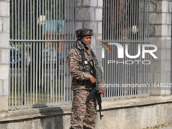 An Indian paramilitary soldier guards outside a vote counting center for the local assembly elections in Srinagar, Jammu and Kashmir, on Oct...