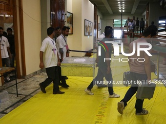 Kashmiri election officials carry a trunk loaded with electronic voting machines as the counting of votes commences for the local assembly e...