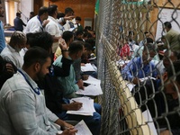 Political party representatives watch as election officials count votes for the local assembly elections at a counting center in Srinagar, J...