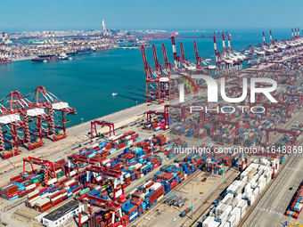 Cargo ships load and unload containers in the Qingdao area of the China (Shandong) Pilot Free Trade Zone in Qingdao, China, on October 8, 20...