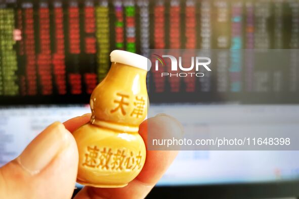 A shareholder checks the stock market with suxiao jiuxin pills (medicine for the heart) in Qingdao, China, on October 8, 2024. 