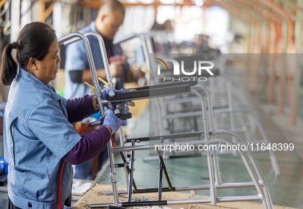 Workers rush to make Japanese-ordered products on the wheelchair production line of Zhongjin Medical Equipment Taizhou Co., Ltd. in Taizhou,...