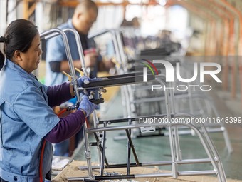 Workers rush to make Japanese-ordered products on the wheelchair production line of Zhongjin Medical Equipment Taizhou Co., Ltd. in Taizhou,...