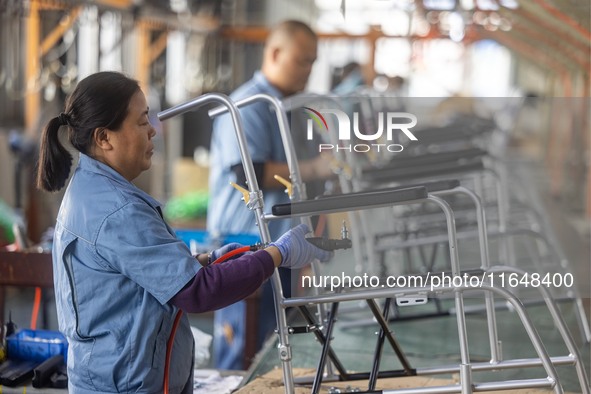 Workers rush to make Japanese-ordered products on the wheelchair production line of Zhongjin Medical Equipment Taizhou Co., Ltd. in Taizhou,...