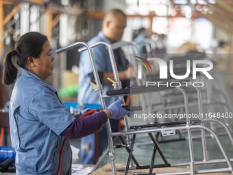 Workers rush to make Japanese-ordered products on the wheelchair production line of Zhongjin Medical Equipment Taizhou Co., Ltd. in Taizhou,...