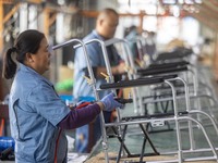 Workers rush to make Japanese-ordered products on the wheelchair production line of Zhongjin Medical Equipment Taizhou Co., Ltd. in Taizhou,...