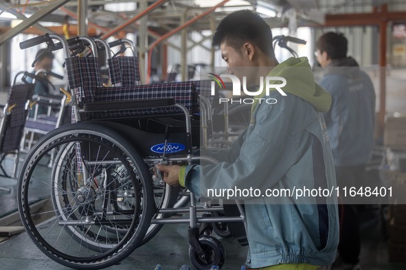 Workers rush to make Japanese-ordered products on the wheelchair production line of Zhongjin Medical Equipment Taizhou Co., Ltd. in Taizhou,...