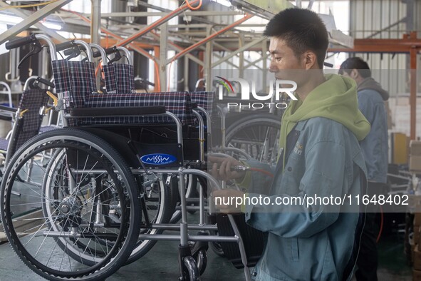 Workers rush to make Japanese-ordered products on the wheelchair production line of Zhongjin Medical Equipment Taizhou Co., Ltd. in Taizhou,...