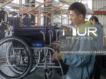 Workers rush to make Japanese-ordered products on the wheelchair production line of Zhongjin Medical Equipment Taizhou Co., Ltd. in Taizhou,...