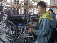 Workers rush to make Japanese-ordered products on the wheelchair production line of Zhongjin Medical Equipment Taizhou Co., Ltd. in Taizhou,...