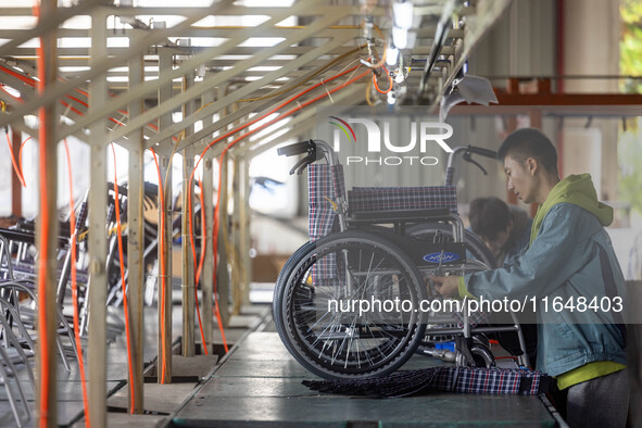 Workers rush to make Japanese-ordered products on the wheelchair production line of Zhongjin Medical Equipment Taizhou Co., Ltd. in Taizhou,...