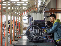 Workers rush to make Japanese-ordered products on the wheelchair production line of Zhongjin Medical Equipment Taizhou Co., Ltd. in Taizhou,...