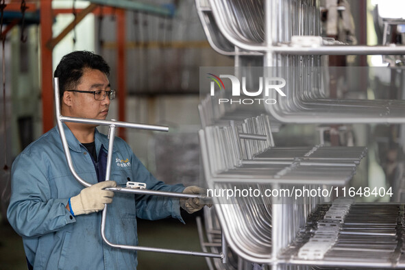 Workers rush to make Japanese-ordered products on the wheelchair production line of Zhongjin Medical Equipment Taizhou Co., Ltd. in Taizhou,...