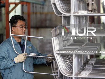 Workers rush to make Japanese-ordered products on the wheelchair production line of Zhongjin Medical Equipment Taizhou Co., Ltd. in Taizhou,...