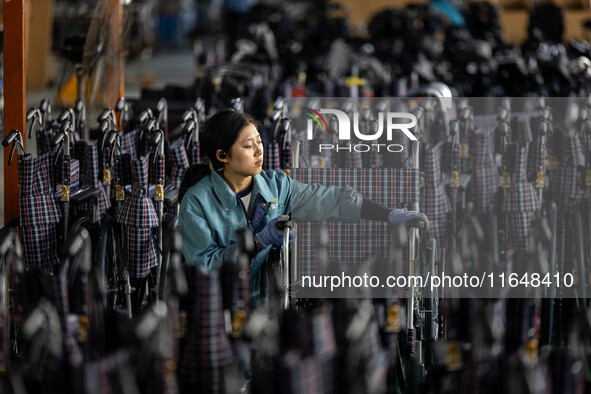 Workers rush to make Japanese-ordered products on the wheelchair production line of Zhongjin Medical Equipment Taizhou Co., Ltd. in Taizhou,...